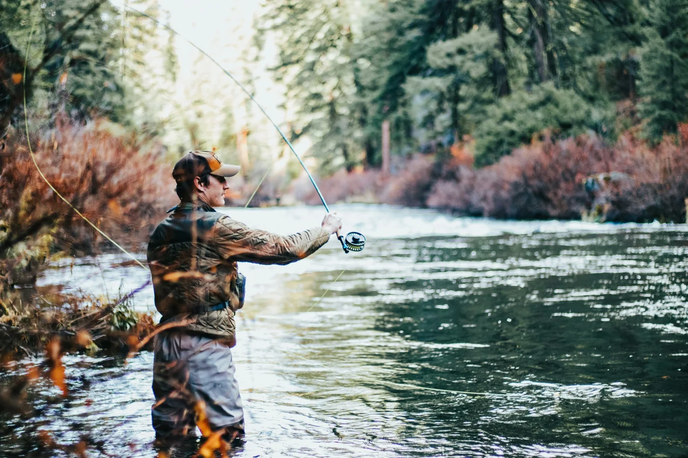 Hands gently releasing a trout back into clear water